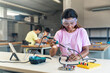 African American High School teenage Student wearing protective goggles soldering electronics circuit in the science technology workshop - Digital Innovation in Education