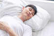 © kaew6566 - Tired asian handsome man sleeping peaceful on white pillow comfortable in morning at apartment white background. Casual asian young male asleep cozy good dream in bedroom. Lifestyle relax concept