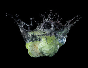 Wall Mural - head of lettuce with water splash isolated on black background,lettuce washing