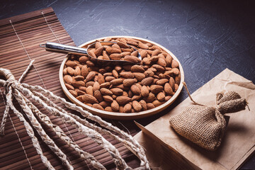 Wall Mural - Roasted Delicious Almond on brown wooden table, Almond in wooden plate on wooden table.