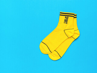 Wall Mural - Yellow socks with black trim on a blue background. Flat lay.