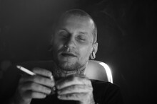 Grayscale Portrait Of Man Sitting And Smoking