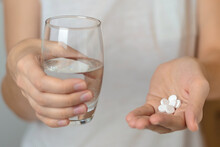 Person Holding Glass Of Water And Medicines