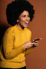 Woman in yellow knit sweater holding smartphone
