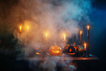 Halloween Pumpkins With Burning Candles On Dark Background