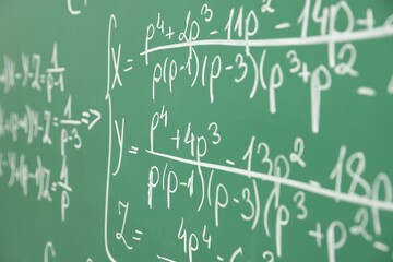 Many different math formulas written on chalkboard, closeup