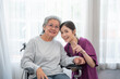 © kelvn - Asian young nurse taking care and talking mature female patient sitting on wheelchair in hospital. Healthcare concept.