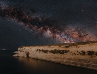 Canvas Print - Beautiful view of the smooth sea with a cliff against the background of the Milky Way.