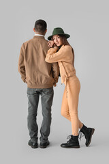 Fashionable young couple in autumn clothes on light background