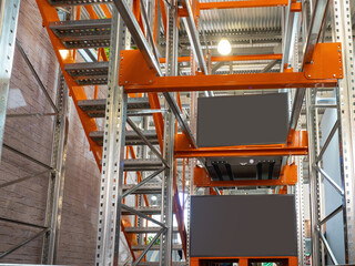 Poster - Warehouse automated. Steel racks with rails for moving flights. Warehouse racks for work with automated equipment. Iron mezzanine with cargo on orange pallets. Warehouse automated equipment