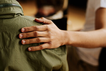hand of young supportive man consoling his friend or one of attendants with post traumatic syndrome 