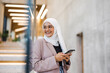 Young muslim woman using smartphone indoors
