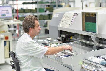 Wall Mural - engineering in microelectronics: workers in the production and assembly of electronic high tech components in a modern factory