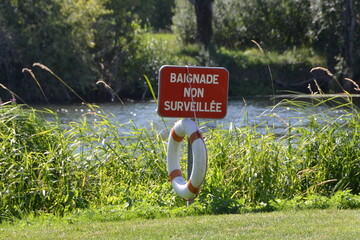 baignade interdite, panneau rouge et bouée de sauvetage, baignade non surveillée