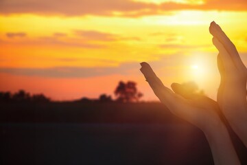 Wall Mural - Human hands on golden sky background