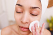 © Wavebreak Media - Happy biracial woman removing make-up on face in bathroom