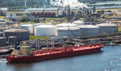 Wall Mural - Oil tanker moored an oil terminal with fuel storage silos in an industrial port