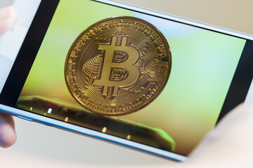 Finance investment business risk. Bitcoin on screen smartphone while Businessman checking photo Gold Bitcoins circuit in mobile for daily check in cryptocurrency. Blockchain idea