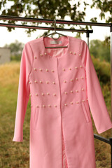 Wall Mural - A beautiful pink coat hangs on a hanger