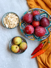 Canvas Print - Still life with red plums on a blue ceramic plate. Eating fresh concept. 