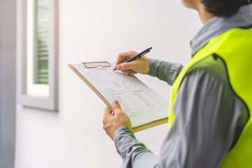 Building inspection, contractor asian young man, male inspecting home, reconstructed construction, renovation or check defect, before finish handing it over to client. Engineering worker, copy space.