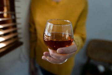 hands holding glass of whiskey.