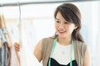© amorn - Closeup of happy asian female fashion designer choosing new womenswear collection in the tailor shop. dressmaker, tailor or needlewoman and dressmaking concept