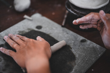 Wall Mural - View of male hands works with clay makes future ceramic plate, ceramic artist makes classes of hand building in modern pottery workshop, creative people handcrafted design