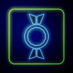 Poster - Glowing neon Candy icon isolated on blue background. Vector