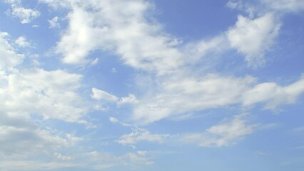 Wall Mural - Blue sky with slowly moving white clouds. Atmosphere of calm relaxation.