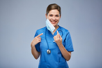 Wall Mural - Nurse woman or doctor in blue medical mask points finger. Isolated female portrait.