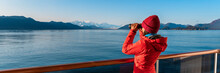 Alaska Glacier Bay Cruise Ship Passenger Looking At Mountains With Binoculars Exploring Glacier Bay National Park. Woman On Travel Inside Passage Enjoying View. Panoramic Vacation Adventure Banner.