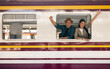 © Chanakon - Couple asian traveller with bag on honeymoon travel by train Sticking head outta the window. Happy Man and woman near platform train station. Planning tourist on vacation time holiday weekend.