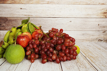 Poster - Various of fruits with Red grape, red apple and green orange on wooden background