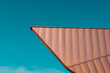 Architecture roofing detail. Cooper elevation panels in a dynamic shape. Modern architecture. Teal and orange.