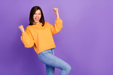 Wall Mural - Photo of youngster pretty cute gorgeous woman wear sweater showing victory emotions crazy fists up empty space promo isolated on violet color background