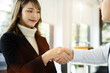 © NINENII - Business men and women shake hands confidently at an office meeting.