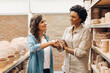 © (JLco) Julia Amaral - Two female ceramists shaking hands in a ceramic shop