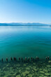 Germany, Bodensee lake view to peaks of alps mountains from coast of the beautiful clear water of the lake of constance with blue sky