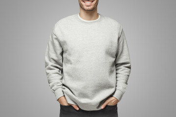 Wall Mural - No face photo of man in sweatshirt, standing isolated on gray background