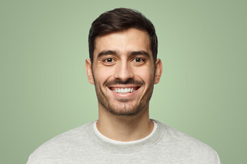 Wall Mural - Close-up of smiling handsome man isolated on green background