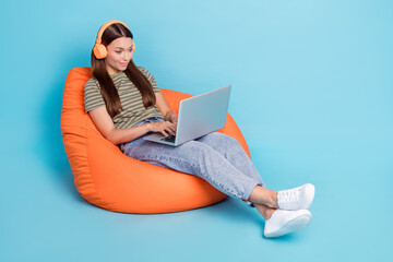 Sticker - Photo of positive woman with long hairstyle wear striped t-shirt headphones typing writing on laptop isolated on blue color background