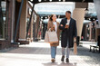 © LIGHTFIELD STUDIOS - smiling woman with shopping bags talking to african american boyfriend while walking on city street.