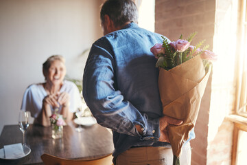 Wall Mural - Surprise, flowers and senior couple in celebration of an anniversary, marriage or birthday at a restaurant. Elderly man giving bouquet of roses to woman during dinner date for love at a coffee shop