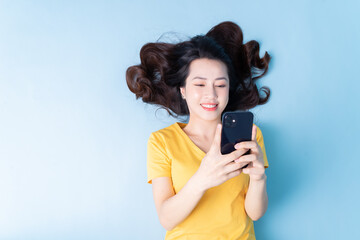 Wall Mural - Image of young Asian woman lying on background