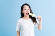 © Timeimage - Young Asian woman eating ice cream on background
