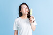 © Timeimage - Young Asian woman eating ice cream on background
