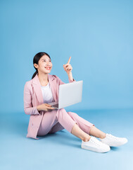 Canvas Print - Young Asian business woman sitting on background