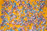 Fototapeta  - Confetti background, basis for a festive design or a postcard. Carnival, abstract wedding or birthday backdrop. Colored circles from paper