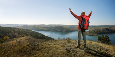 man hiker with open arms on top mountain. freedom active healthy lifestyle adventure journey vacations. banner with copy space.